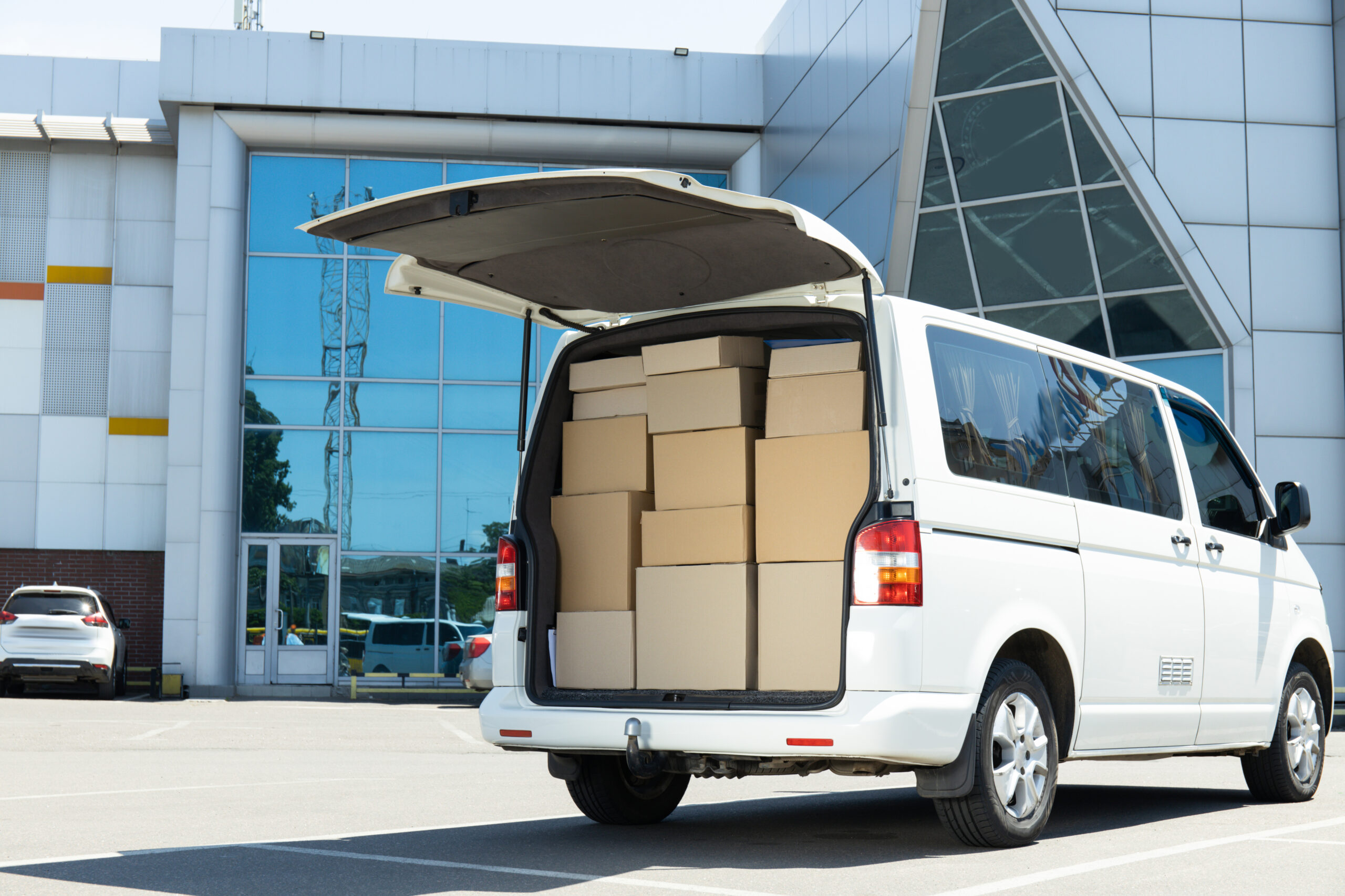 A white delivery service car with boxes inside